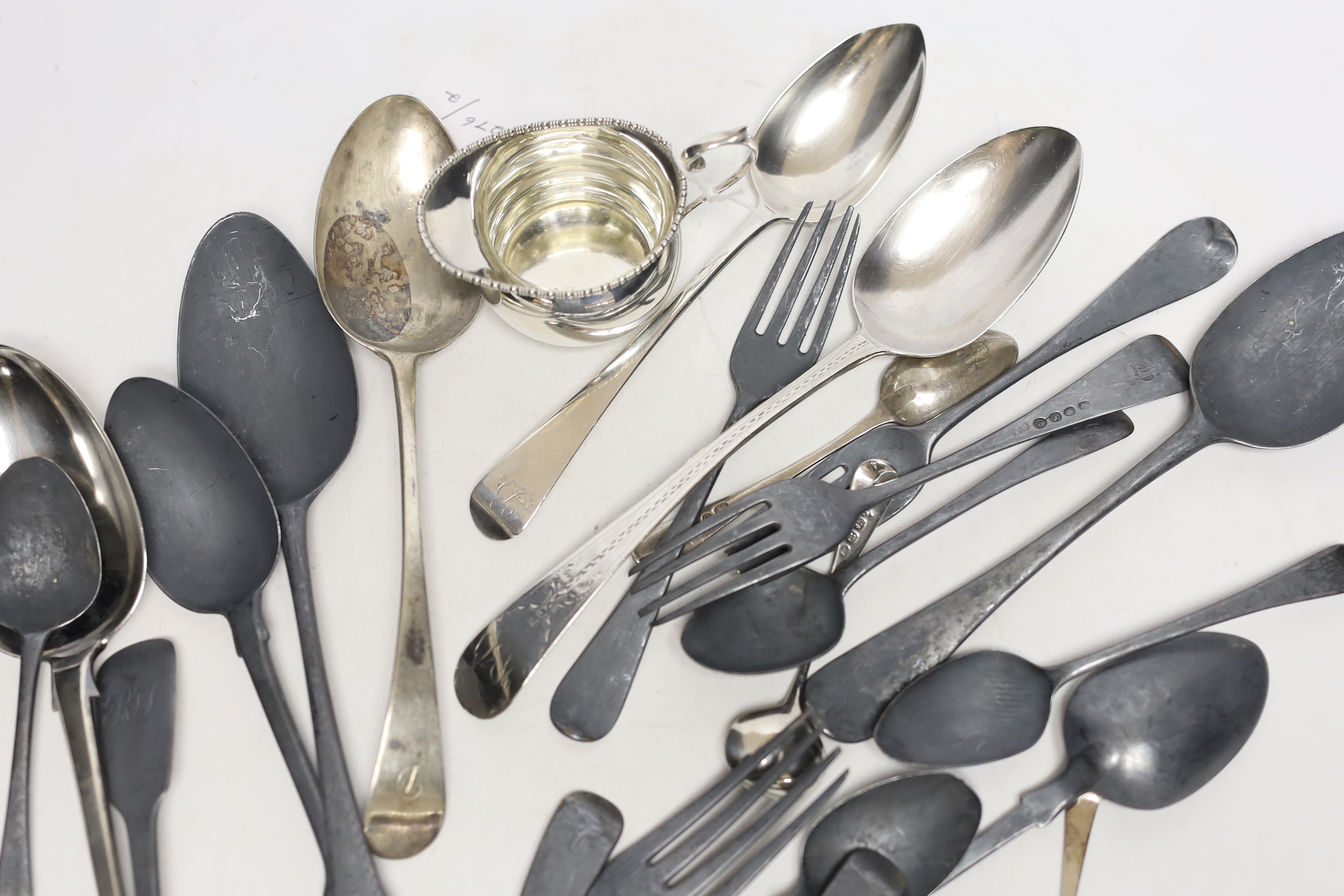 Twenty two assorted items of mainly 19th century flatware, various patterns, dates and makers, together with a small silver cream jug, 25.4oz.